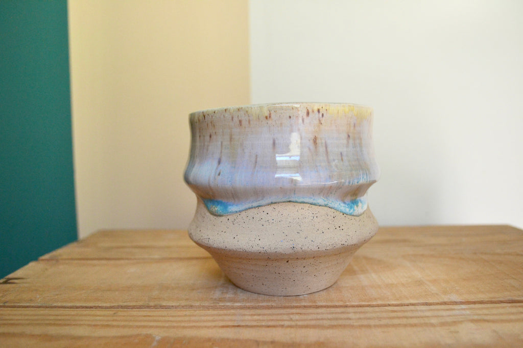 Ceramic vase with a textured surface on a wooden surface.
Speckled clay mayco glaze.